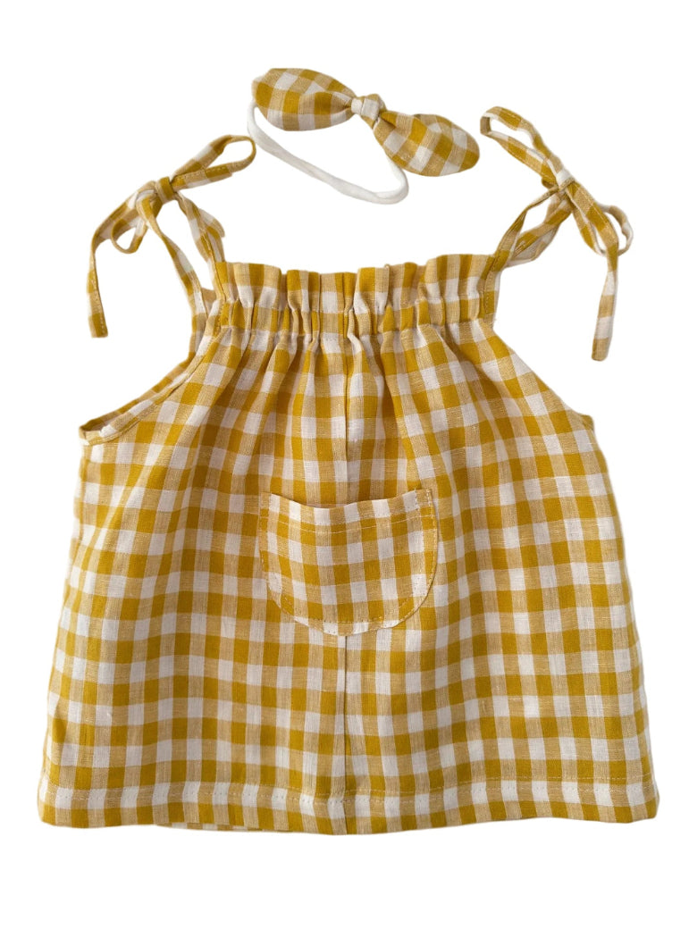 A yellow and white gingham check baby romper set including a sleeveless top with a front pocket and a matching bow headband, displayed on a clean white background.